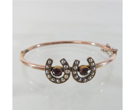 A Victorian gold plated bangle, set with a double seed pearl horseshoe, cased