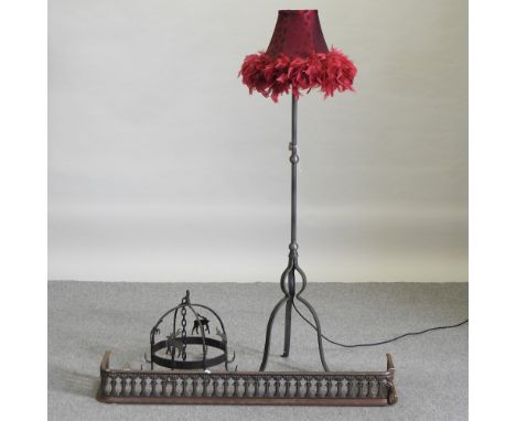 An iron fender, together with a hanging rack and an iron standard lamp and shade, 150cm high overall (3)
