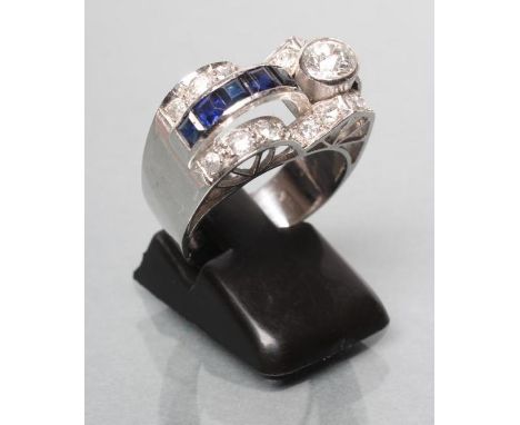 AN ART DECO SAPPHIRE AND DIAMOND COCKTAIL RING, the oblong panel collet set with a brilliant cut diamond of approximately 0.5