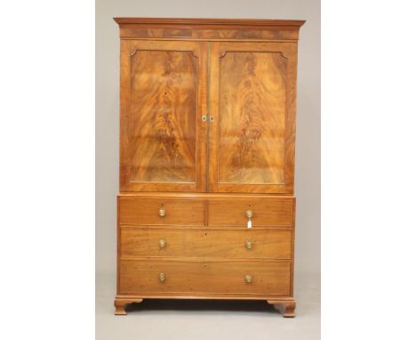 A GEORGIAN MAHOGANY LINEN PRESS, late 18th century, the moulded cornice over two doors with brass trim and flame veneered cut