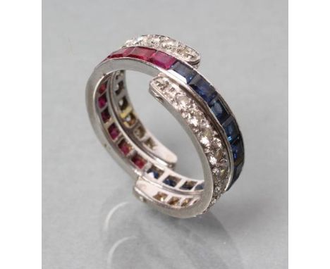 A DIAMOND, RUBY AND SAPPHIRE ETERNITY RING, the central band channel set with sapphires and rubies between two hinged bands o