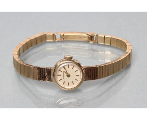 A LADY'S 9CT GOLD LONGINES WRISTWATCH, the champagne dial with applied gilt metal batons, the seventeen jewel movement number