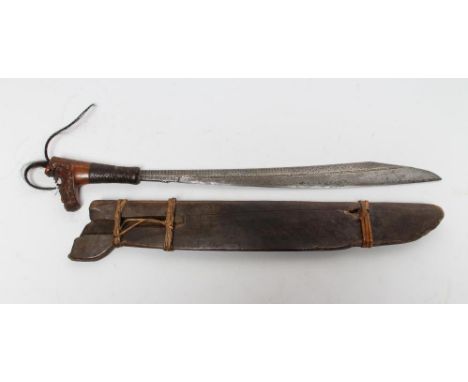 A DAYAK MANDAU HEADHUNTERS SWORD, the 19 1/4" blade of typical form, engraved with foliate and geometric decoration together 