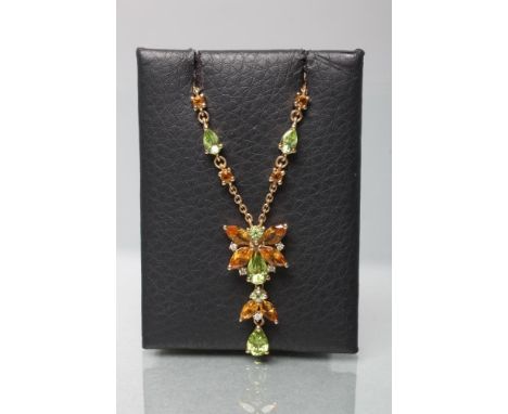 A BUTTERFLY PENDANT with citrine wings and peridot head and thorax, with diamond points between, hung with two further citrin