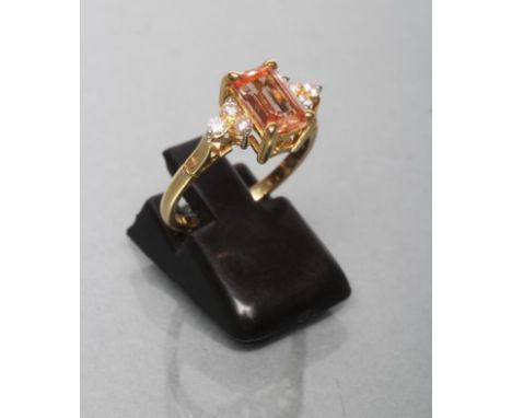 A TOPAZ AND DIAMOND DRESS RING, the Princess cut pale brown topaz print set to shoulders each with three diamond points to a 