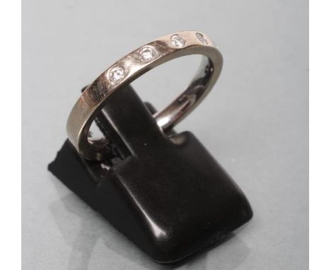 A WHITE WEDDING RING set with five small brilliant cut diamonds, stamped 750, size N 1/2 (Est. plus 21% premium inc. VAT)4.5g