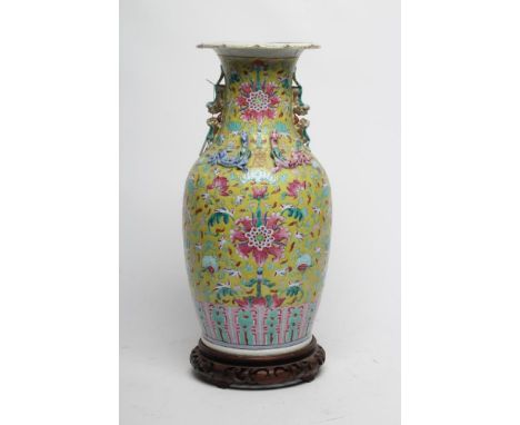 A CHINESE PORCELAIN VASE of baluster form with everted shaped rim and two shi-shi handles, painted in pink with large flowers