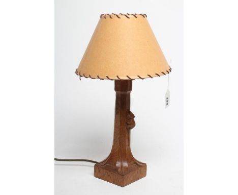 A ROBERT THOMPSON ADZED OAK TABLE LAMP, the faceted tapering stem with carved mouse trademark in high relief, the square base