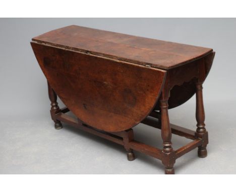 AN OAK DROP LEAF TABLE , c.1700, the oval plank top on arched frieze with drawer to one end, raised on ring and baluster turn