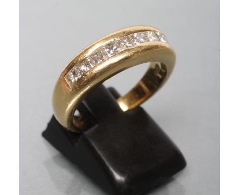 A NINE STONE DIAMOND HALF HOOP ETERNITY RING, the princess cut stones in rub-over channel setting to a plain 18ct gold shank,