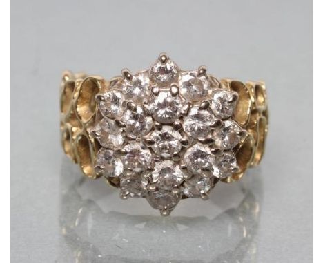 A DIAMOND CLUSTER RING, the nineteen brilliant cut stones point set to modernist 18ct gold open shoulders and a plain shank, 