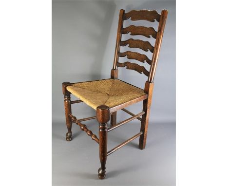 Eight Antique Ladder Back Chairs. The rush-seated chairs with turned legs and stretchers. (af)