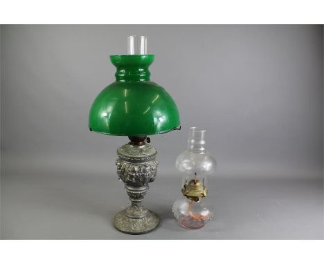 A Late Victorian Oil Lamp. The lamp with metal base glass reservoir and green glass shade and funnel together with a small cl