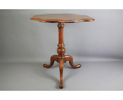 A Burr Walnut Occasional Table. The scallop-shaped table inlaid with a star motif and supported on tripod legs, approx 68 x 5
