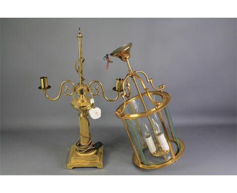 Two Lighting Fittings. This lot includes a brass and glass ceiling light with a central bulb trio, approx 52 cms h and a bras