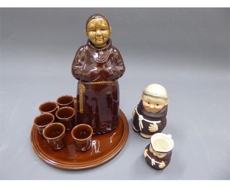 A Ceramic Decanter and Tots. The glasses and decanter modelled as a monk, together with a Goebel monk jar and cover and a Goe