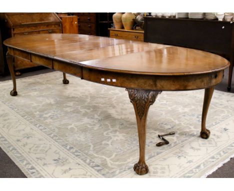 A mahogany extending oval dining table. With three leaves, on cabriole legs with ball and claw feet, complete with winder, H7