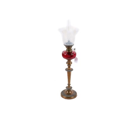 A brass candlestick/oil lamp. With cranberry glass reserve and opaline shade, H59cm. 