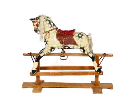 A vintage rocking horse. Painted black and cream, with leather and faux leather tack, alert eyes and mouth open, white mane a