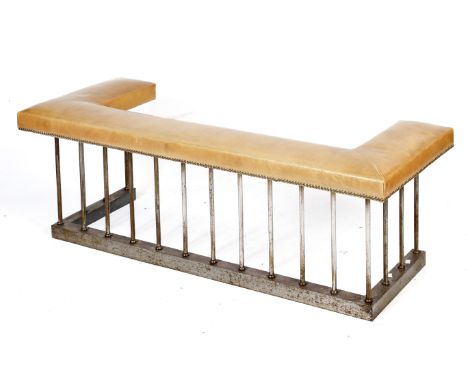 A contemporary leather topped club fender. A steel base with steel upright supports, brown leather cushioned top with brass s
