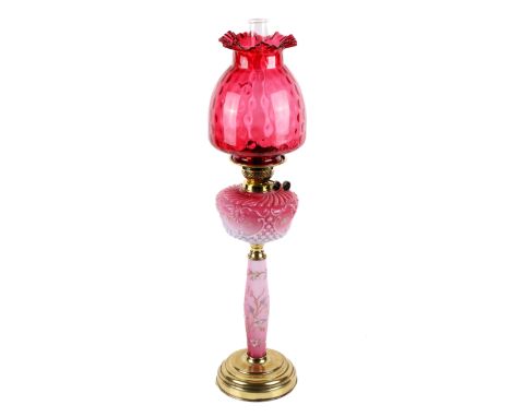 A 19th century pink opaline glass oil lamp. Of baluster form with brass fittings, the reservoir having moulded details, the s
