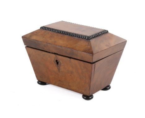 A 19th century burr walnut tea caddy. Of sarcophagus form with beaded top panel, raised on bun feet, the hinged inner lids mo