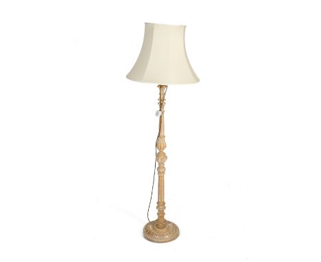 A carved wooden standard lamp. On a circular base complete with shade, H180cm.