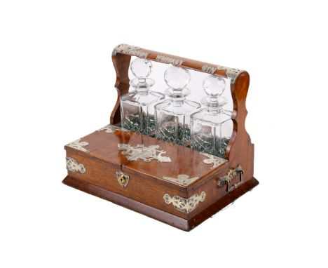 A Victorian oak and silver plated tantalus. Silver plated on brass top and corner decoration, with drop handles to the side. 