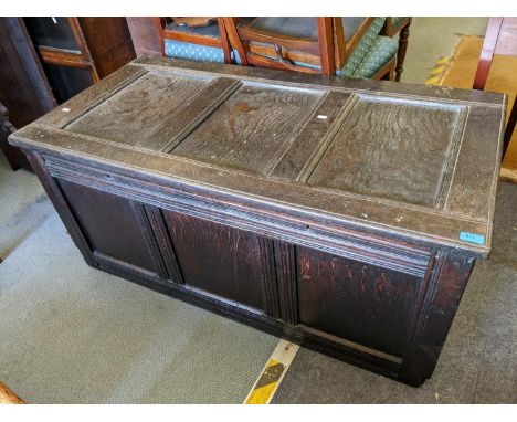 A 18th century oak coffer having a hinged top above four panel front 