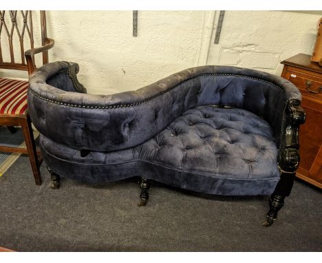 A late 20th century love seat with a black gloss finished frame, button upholstered in blue velvet fabric, on ring turned tap