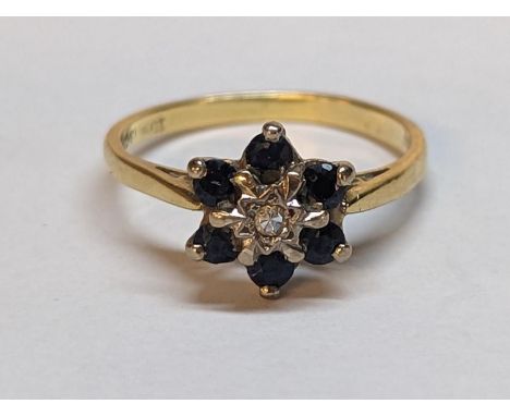 A stamp 18ct gold diamond and ruby cluster ting, inset with a central diamond within the Star of David and six rubies, 2.6g 