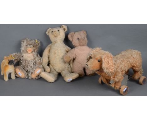 Fünf Steiff-Tiere: Ein Boxer-Hund (H=16,5 cm), drei Bären (H=25 bis 40 cm) und ein Dackel auf Rollen (H=26,5 cm). (bespielt u