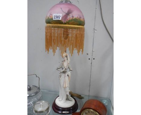 A mid 20th century figural table lamp with glass painted shade.