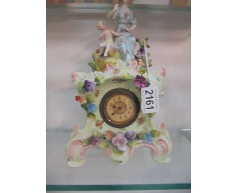A ceramic mantel clock surmounted figures.