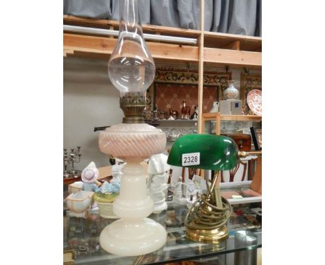 An opaque glass oil lamp and a desk lamp with green shade.