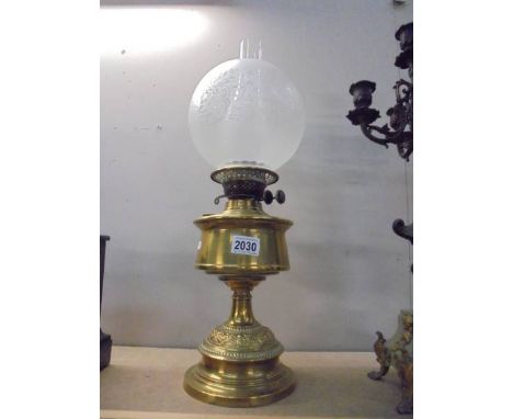 A brass oil lamp with later etched glass shade. COLLECT ONLY.