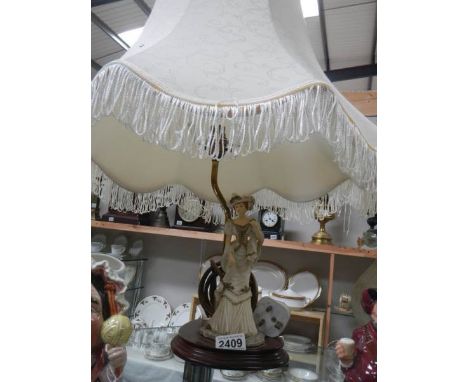 A figural table lamp with large shade.