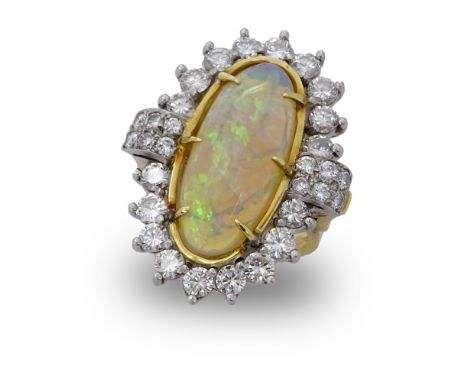 Circa 1970s Oval Cabochon Opal, Diamond, Platinum and 18 Karat Yellow Gold Ring. Opal measures 22mm x 9mm. Diamonds F-G color