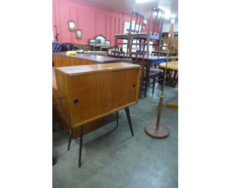 A teak two door record cabinet on stand and a standard lamp 