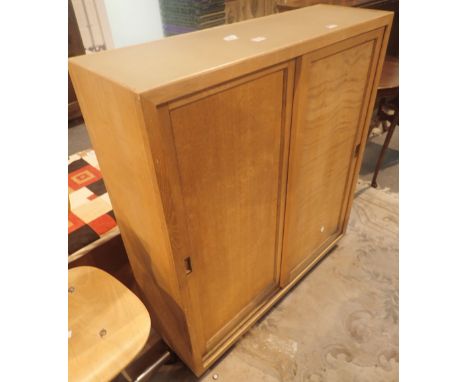 Light oak three shelf cupboard with sliding doors