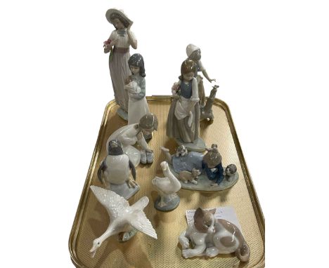 Six Lladro and four Nao ornaments including Girl with Puppies, Penguin, Cat, etc.