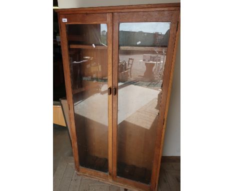 Early to mid 20th C oak gun style cabinet enclosed by two glazed doors with internal shelf and gun racking (87cm x 27cm x 157