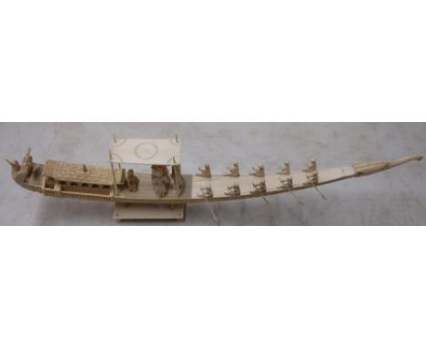 Early 20th C Persian carved ivory tusk in the form of a boat with various figures mounted on rectangular base, with elephant 