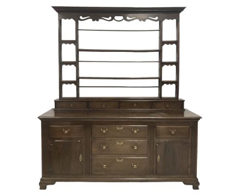 George III oak dresser, the projecting dentil cornice and shaped and pierced apron over two plate racks, six small shelves an