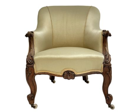 Victorian rosewood armchair, scroll carved arm terminals, the shaped uprights carved with foliage, upholstered in pale yellow