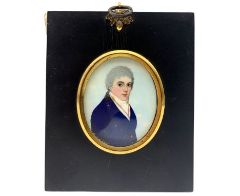 19th century oval portrait miniature, half length watercolour on ivory of a young gentleman wearing a blue coat and in ebonis