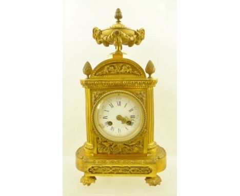 A LATE 19TH CENTURY FRENCH MANTEL CLOCK, having gilt cast metal case, urn finial with goat mask decoration, white enamel dial