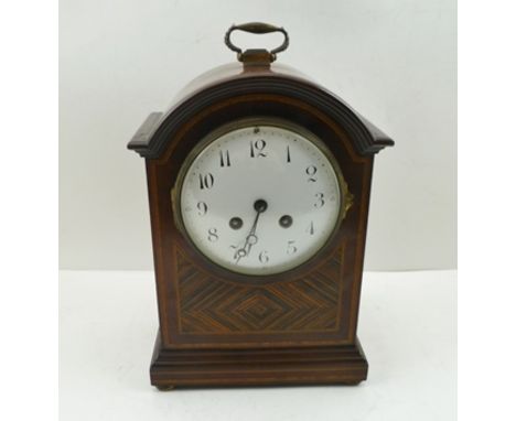 A GEORGIAN DESIGN MAHOGANY CASED TABLE OR MANTEL CLOCK, having arch top case with brass handle, decoratively figured and stri