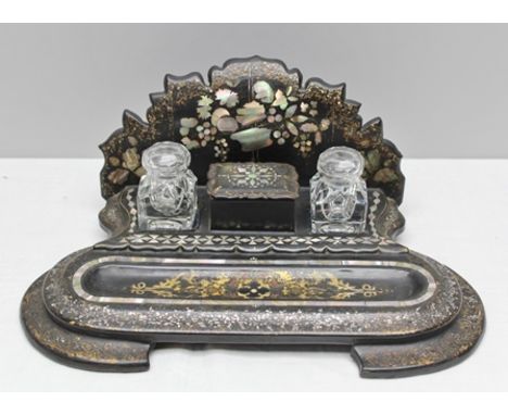 A 19TH CENTURY MOTHER-OF-PEARL AND OVER PAINTED PAPIER MACHE DESK STAND with shaped back, having two moulded glass wells, fla