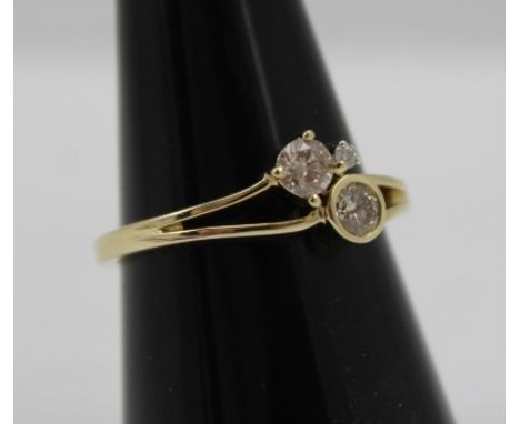 A DIAMOND SET 9CT GOLD RING having three round brilliant cut stones in an abstract setting, approx .360 total carat weight, t